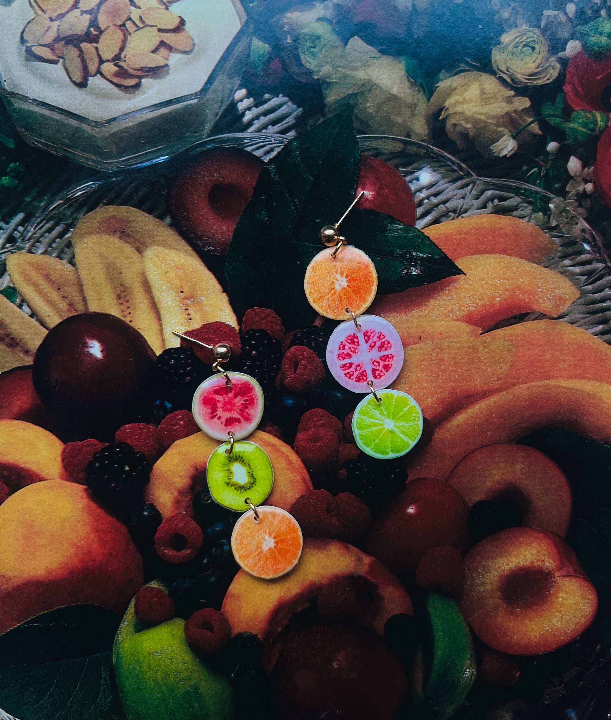 a pair of earrings with fruit slices hanging from them