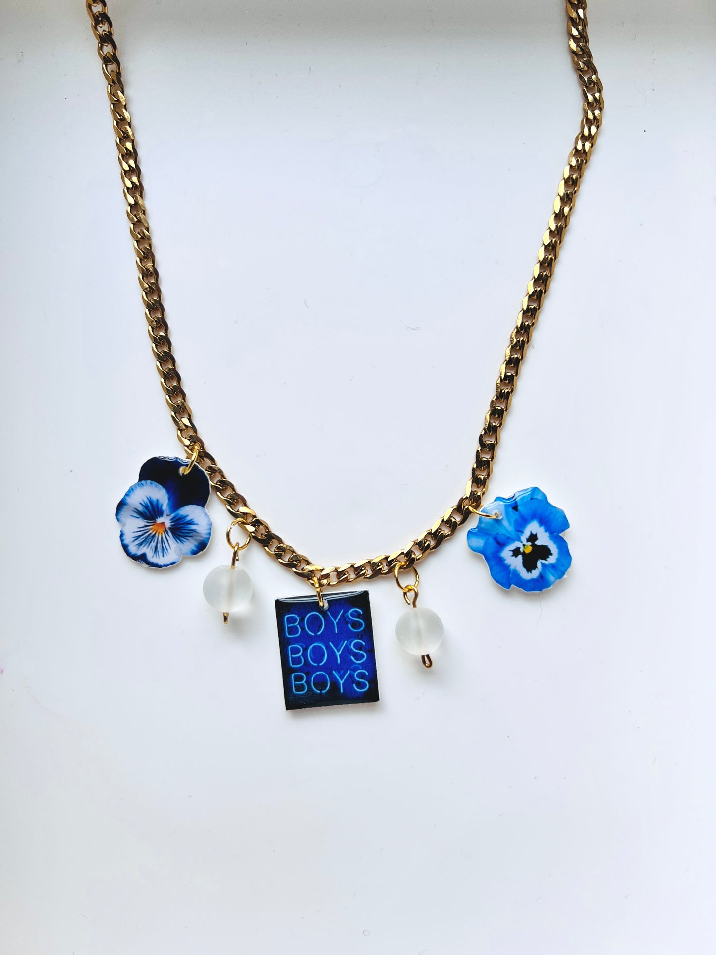 gold plated curb chain necklace with blue and white pansy charms and opalescent beads. 