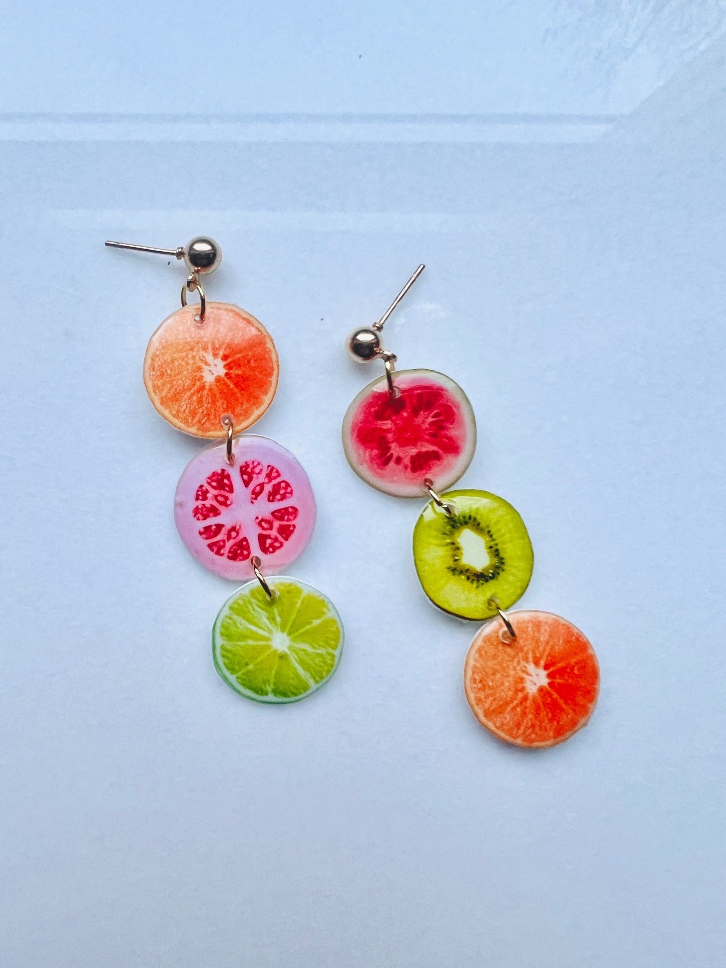 a pair of earrings with fruit slices hanging from them